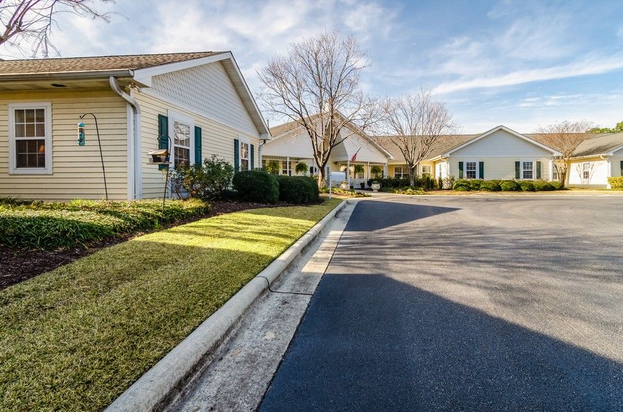 A suburban neighborhood with neatly lined houses and a clear, sunny sky.