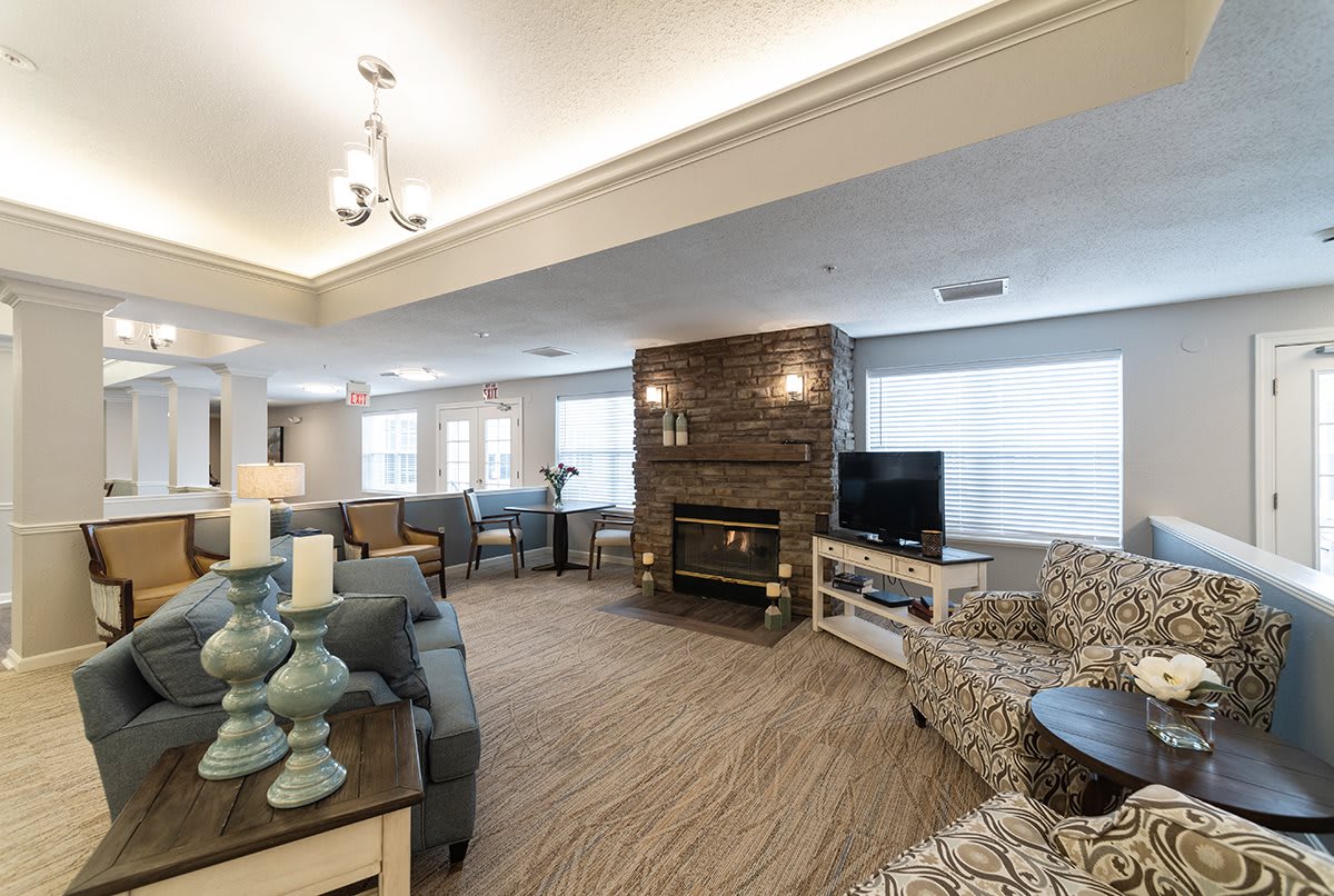 A cozy and spacious living room with a fireplace, comfortable seating, and large windows.