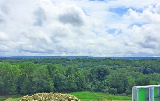A scenic view of a lush green forest under a cloudy sky.