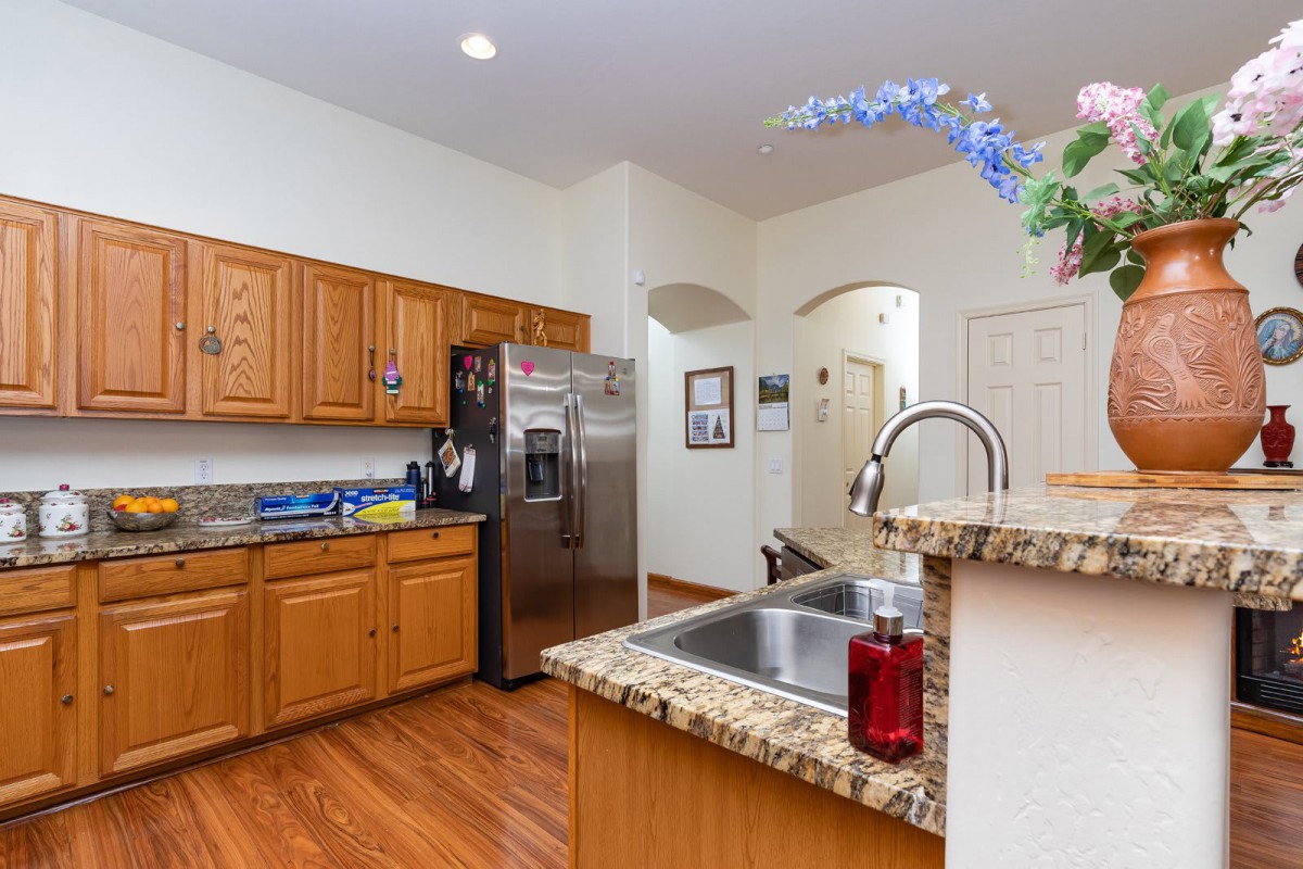 A modern kitchen with wooden cabinets, stainless steel appliances, and granite countertops.