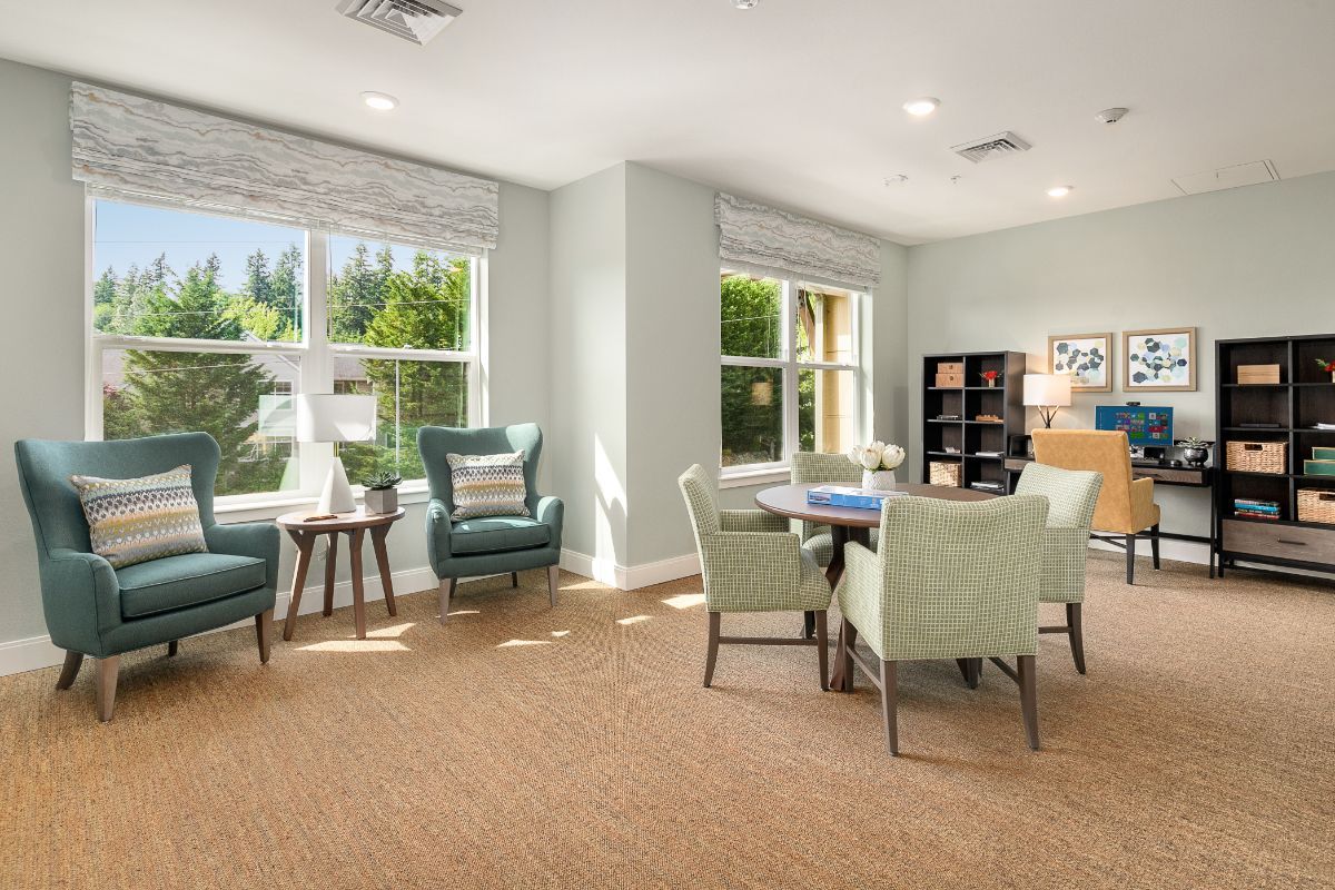 A bright and cozy living room with comfortable seating and a bookshelf.