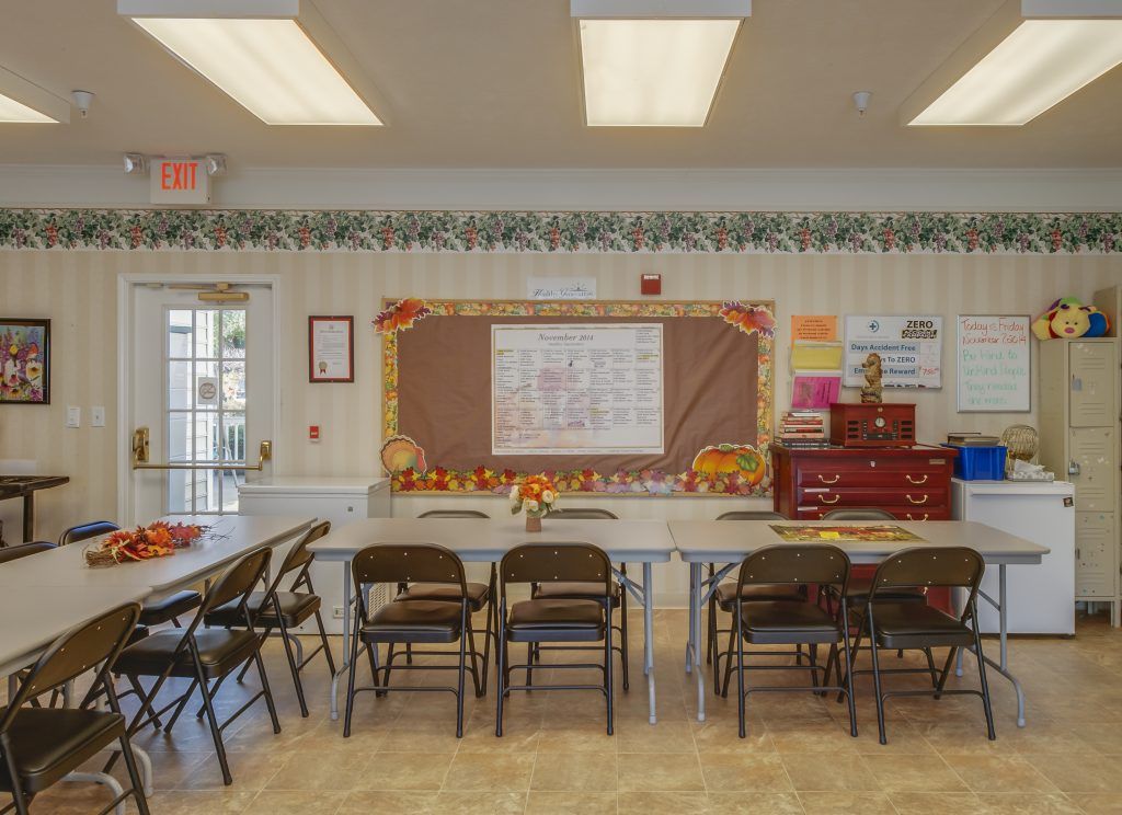 A decorated meeting room with tables and chairs set up, featuring a bulletin board on the wall.