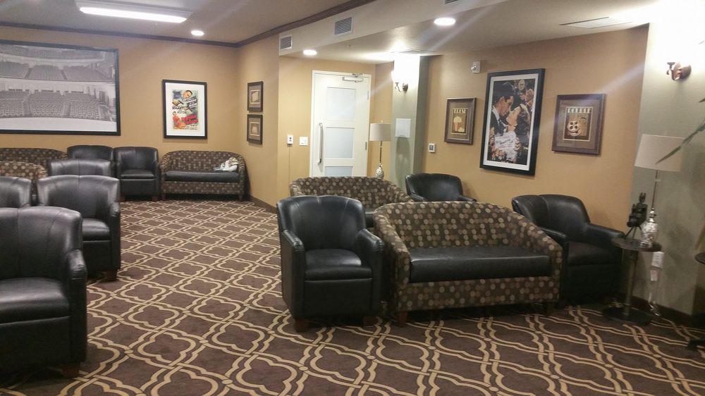A cozy waiting room with patterned carpet, comfortable seating, and artwork on the walls.