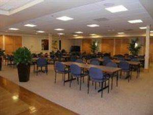 A spacious indoor conference room equipped with multiple tables and chairs, ideal for meetings or group activities.