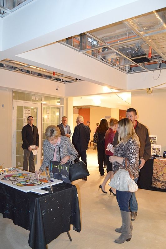 A group of people attending an indoor event with refreshments and conversations.