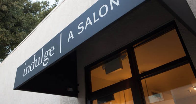 An exterior view of a salon with its signage displayed.