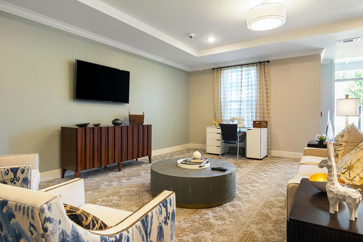 A modern living room featuring stylish furniture and a mounted television.