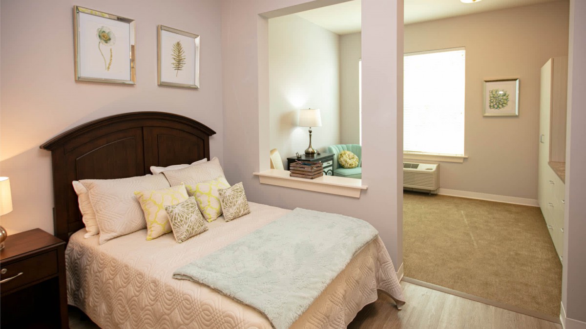 A cozy bedroom with a bed, pillows, and elegant decor.