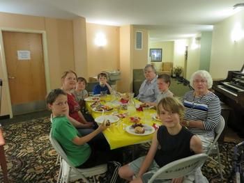 A family gathering around a dining table for a meal.