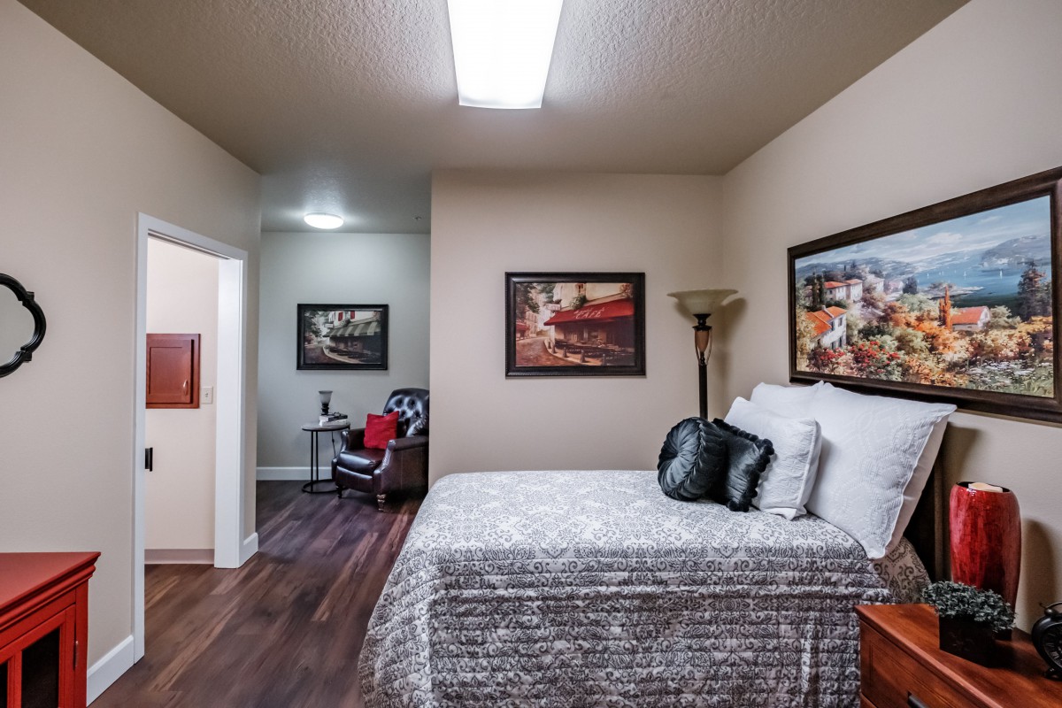 A modern bedroom featuring a comfortable bed, stylish artwork, and cozy decor.
