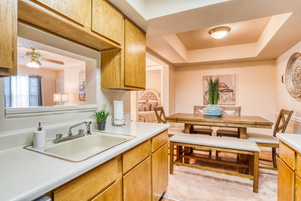 A cozy kitchen with wooden cabinets and a view of the dining area.
