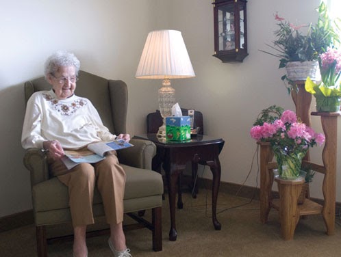 An elderly woman enjoying a quiet moment while reading in a cozy living space.
