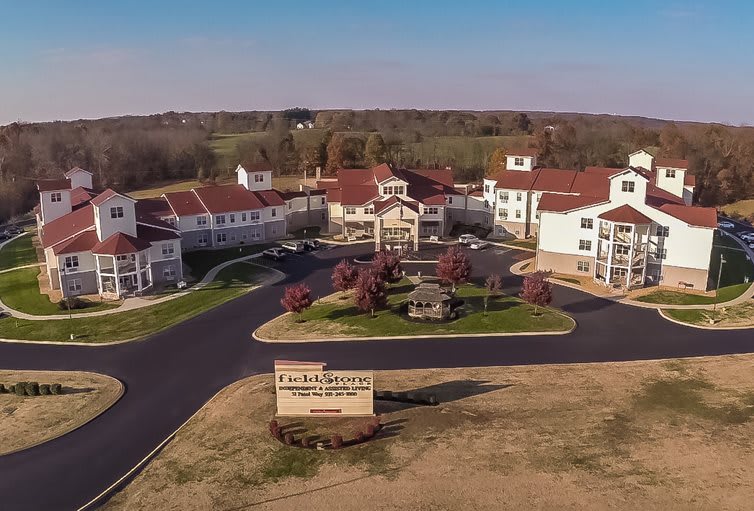 Aerial view of a residential complex with landscaped gardens and driveways.
