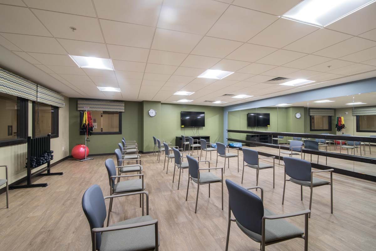 An empty conference room with chairs arranged in rows facing multiple television screens.