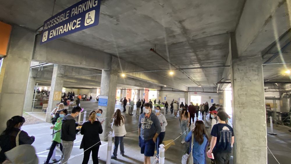 A busy parking garage with a crowd of people walking through.