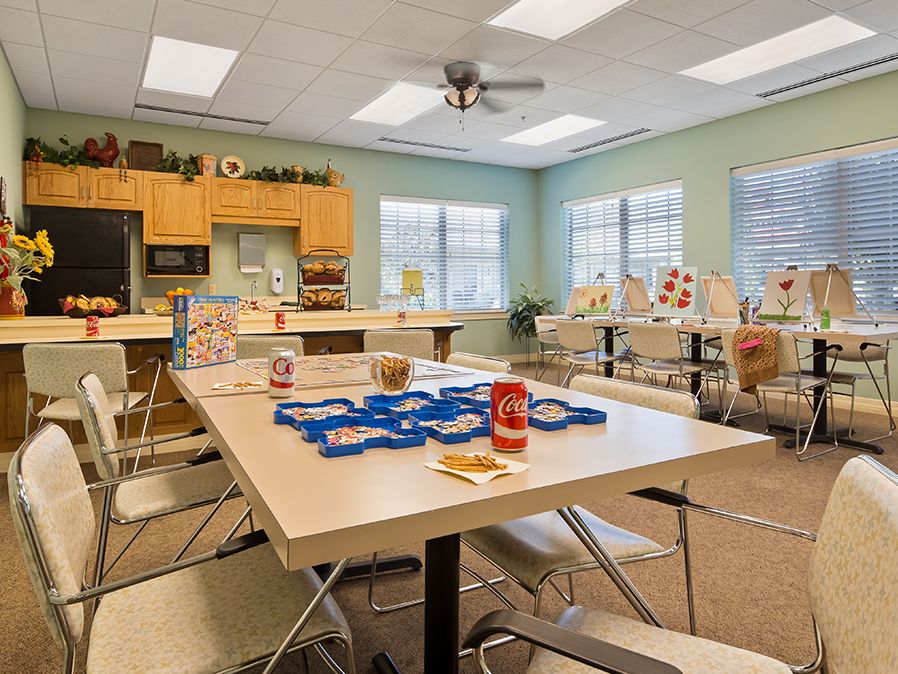 A bright classroom setting with tables, chairs, and various educational materials arranged for learning activities.