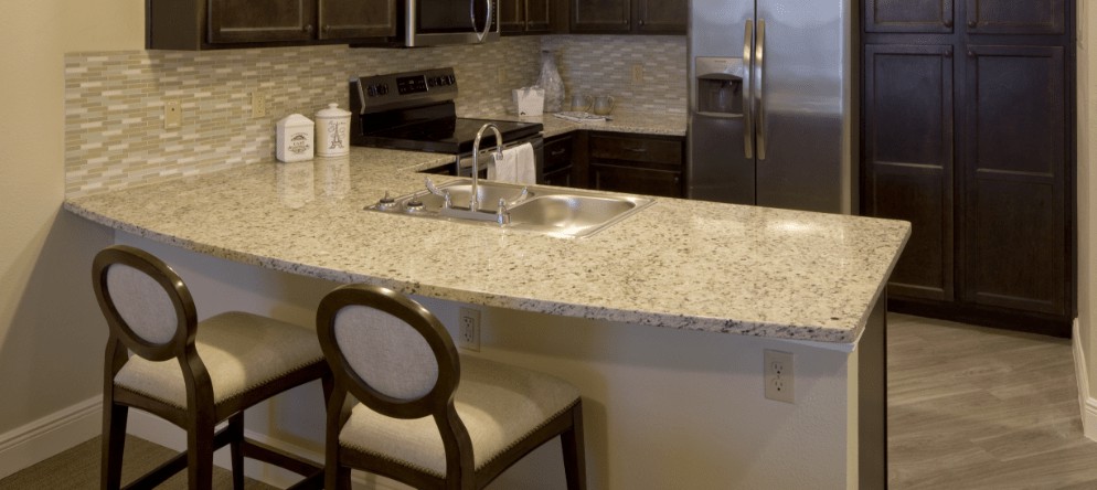 A modern kitchen with granite countertops and stainless steel appliances.