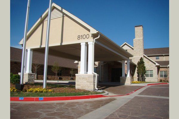 The entrance of a large building with an awning, captured on a clear day.