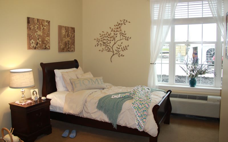 A cozy bedroom with a decorative wall piece and a neatly made bed.
