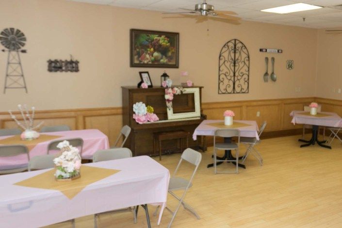 A quaint indoor space with decorated tables and a piano against the wall.