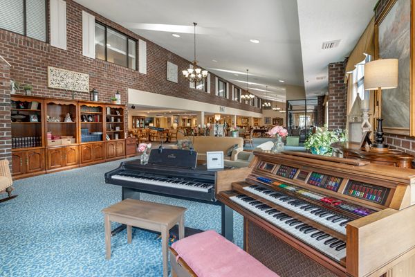 A spacious interior featuring musical instruments, comfortable seating, and bookshelves.