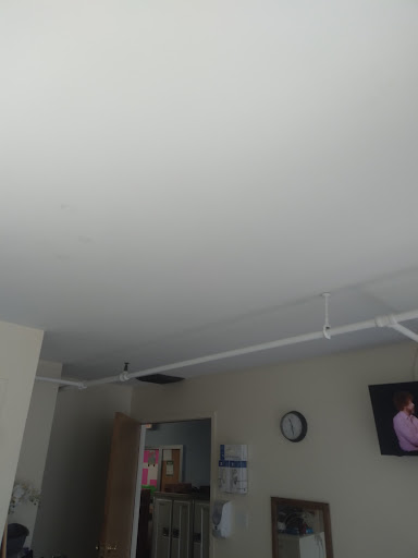 A view of a room featuring a ceiling, a wall clock, and a television.