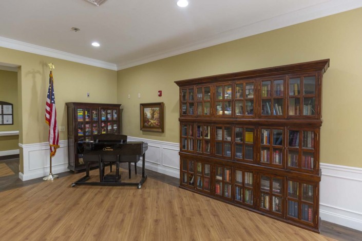 A quiet reading room with wooden bookshelves filled with books and a desk.