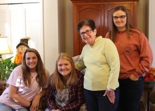 A group of people posing together indoors, smiling at the camera.