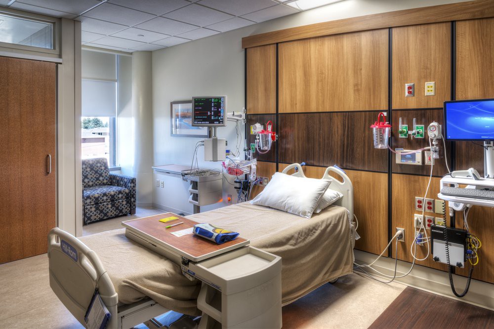 A well-equipped hospital room featuring a patient bed and medical equipment.