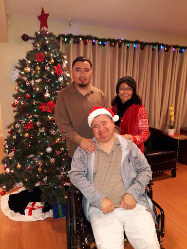 A joyful family gathering in front of a beautifully decorated Christmas tree.