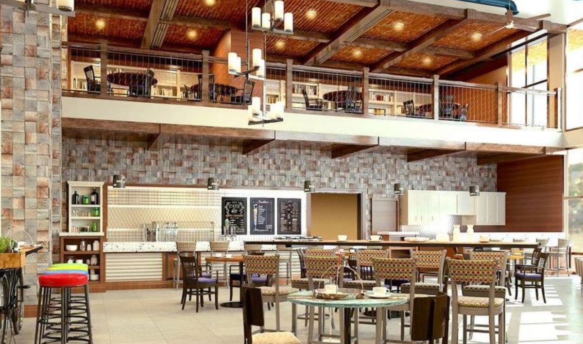 A modern restaurant interior with a loft-style design, featuring a dining area and chandeliers.
