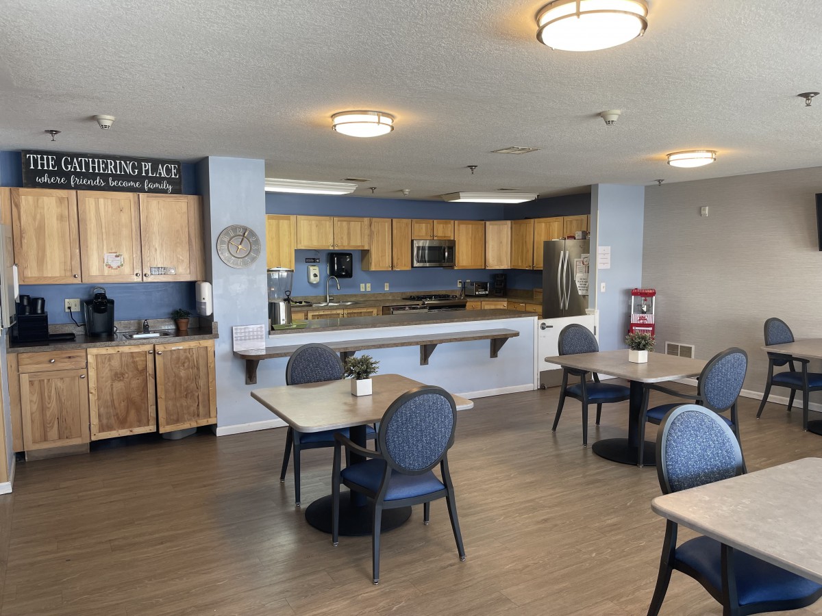 A communal kitchen and dining area with modern appliances and seating.