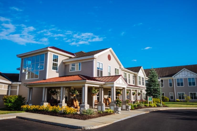 A residential building with a well-maintained garden under a clear blue sky.