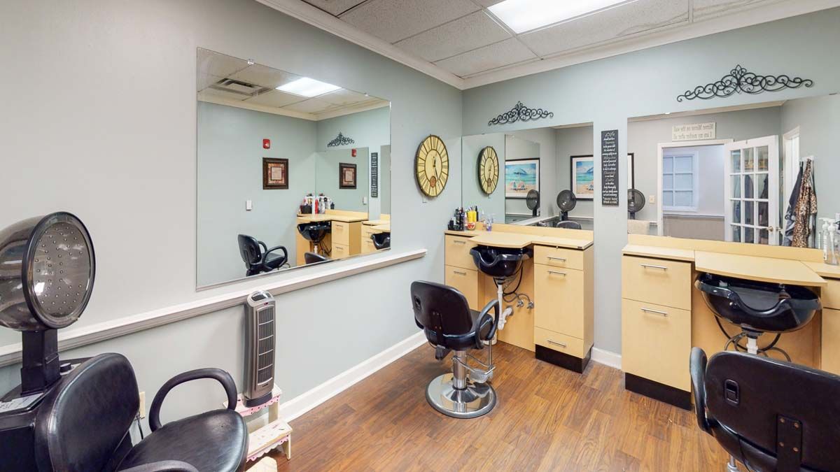 A well-organized salon with hair styling stations, mirrors, and chairs in a neatly designed interior.