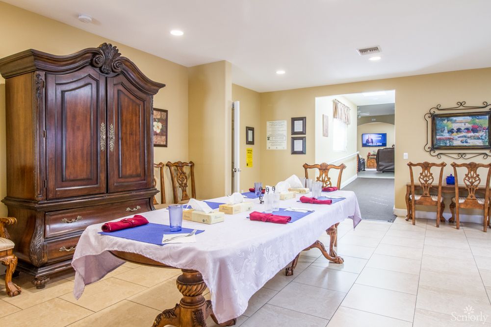 A well-decorated dining room with a table set for a meal, featuring wooden chairs and an elegant cabinet.