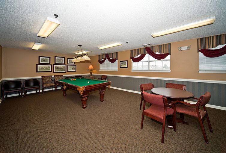 A well-furnished game room featuring a pool table and seating area.
