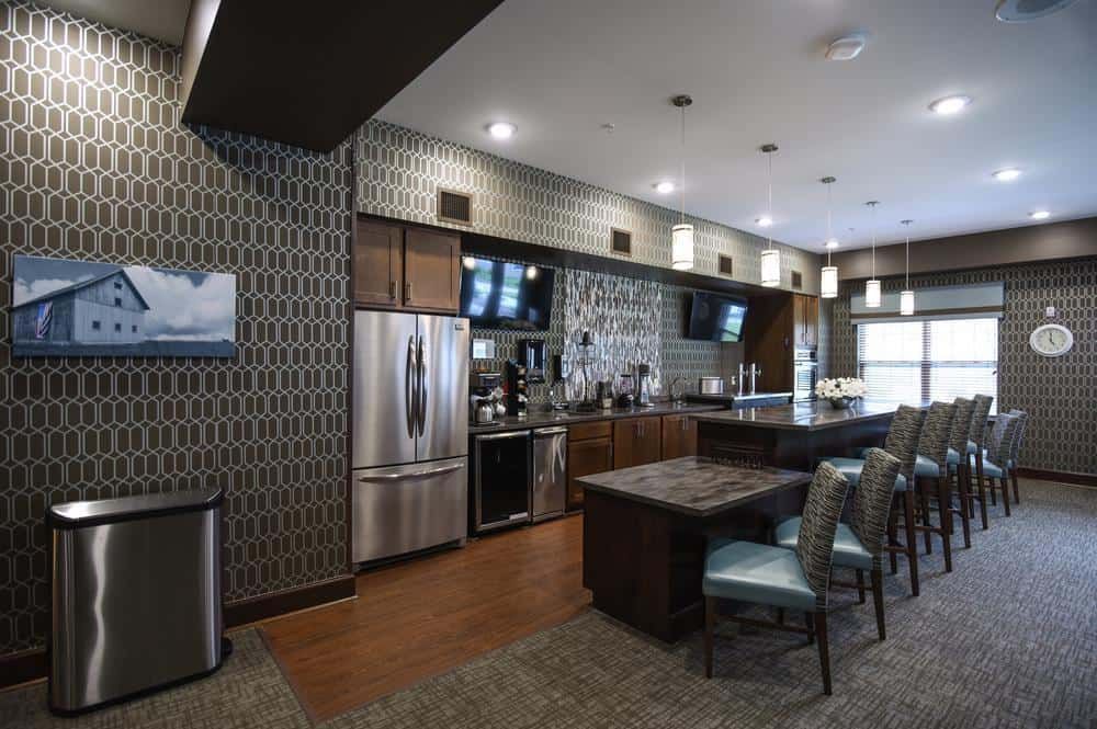 A modern kitchen interior with stainless steel appliances and stylish bar seating.