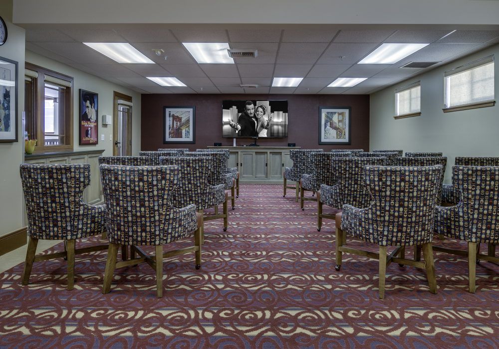A well-arranged conference room with patterned chairs and artwork on the walls.