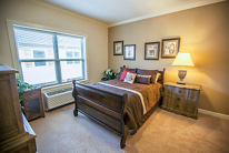 A cozy bedroom with a wooden bed, side table, and decorative elements.