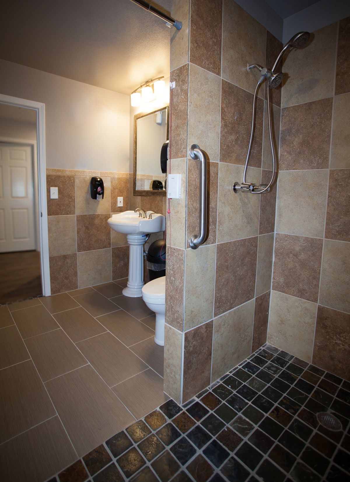 A modern bathroom with a walk-in shower and tiled walls.