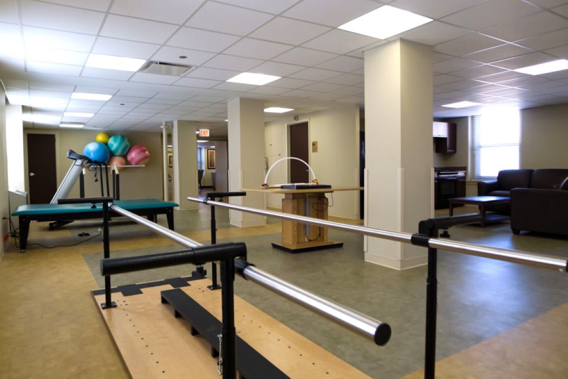 A rehabilitation center with parallel bars and exercise equipment for physical therapy.
