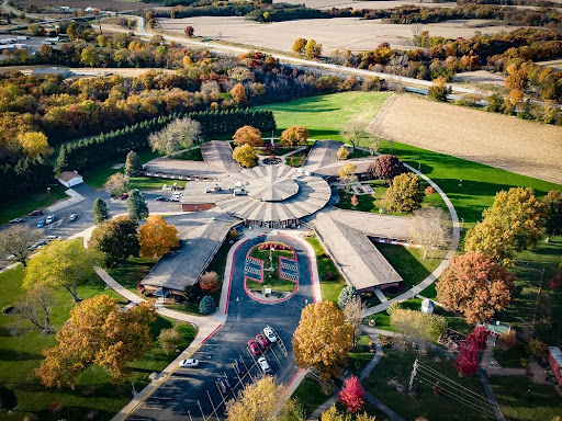 A picturesque aerial view of a building complex surrounded by vibrant autumn foliage.