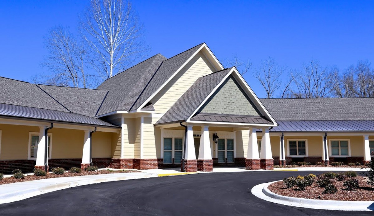 A modern residential building with a sloped roof and driveway.