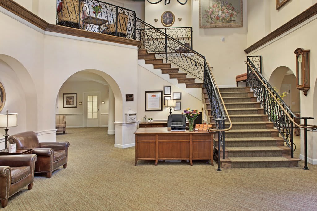 Elegant hotel lobby with a staircase and reception desk.