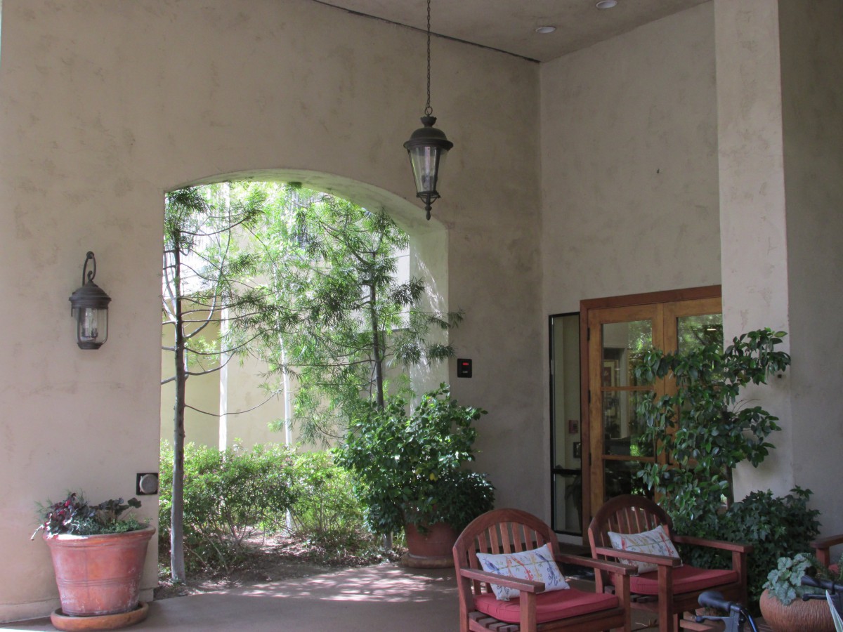 A cozy patio area with seating and lush greenery.