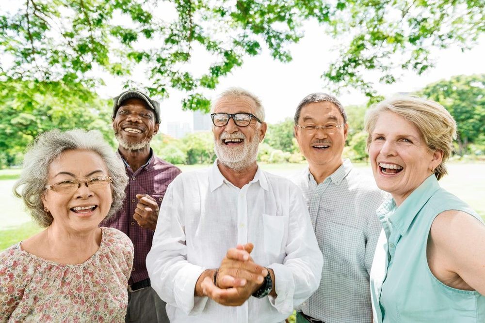 A diverse group of happy seniors enjoying a day outdoors in a park.