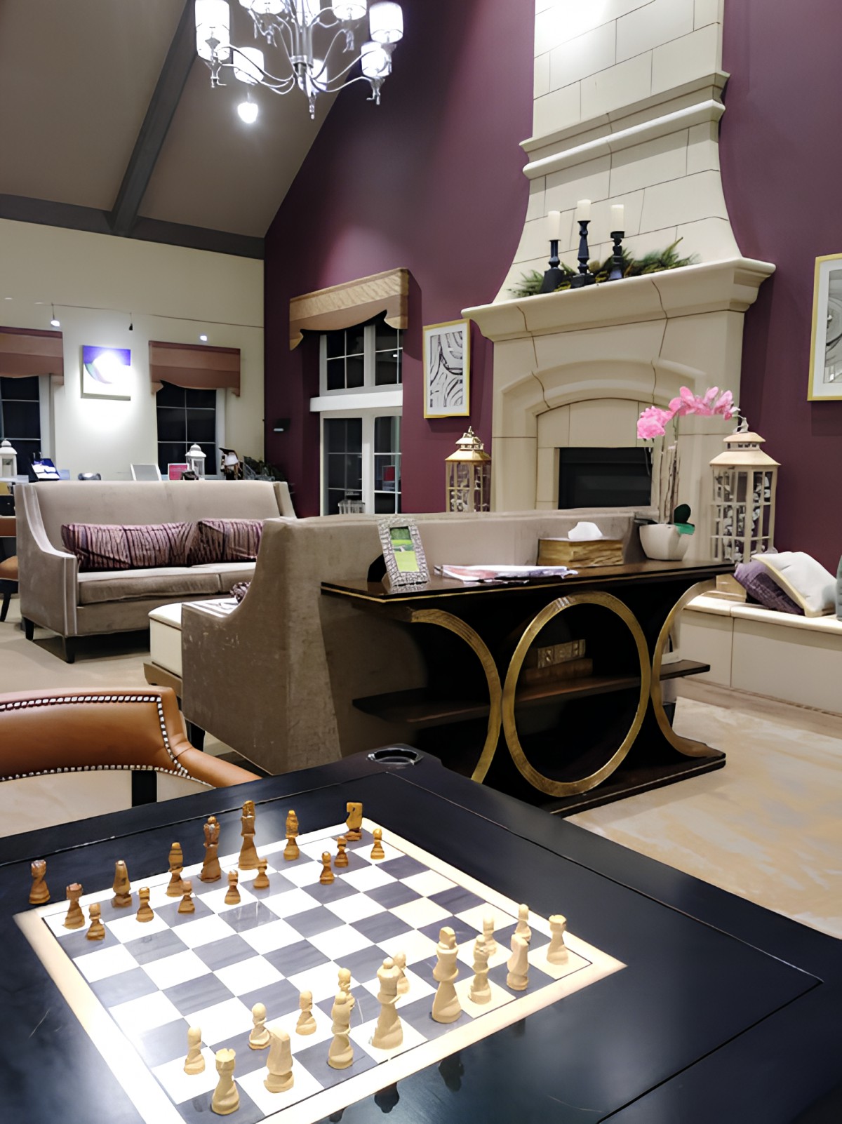 A cozy living room with elegant decor, featuring a chessboard set on the coffee table, comfortable sofas, and a fireplace in the background.