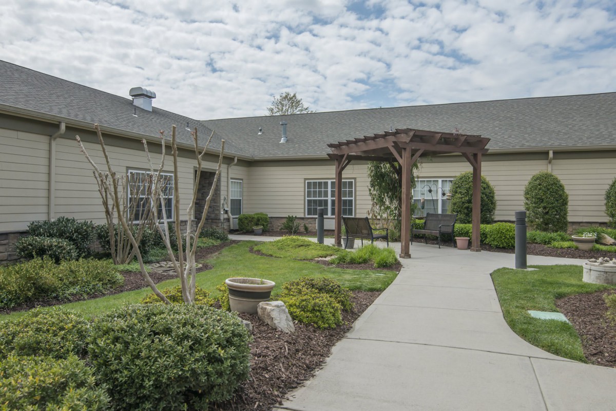A landscaped courtyard with a pathway leading to a building entrance.