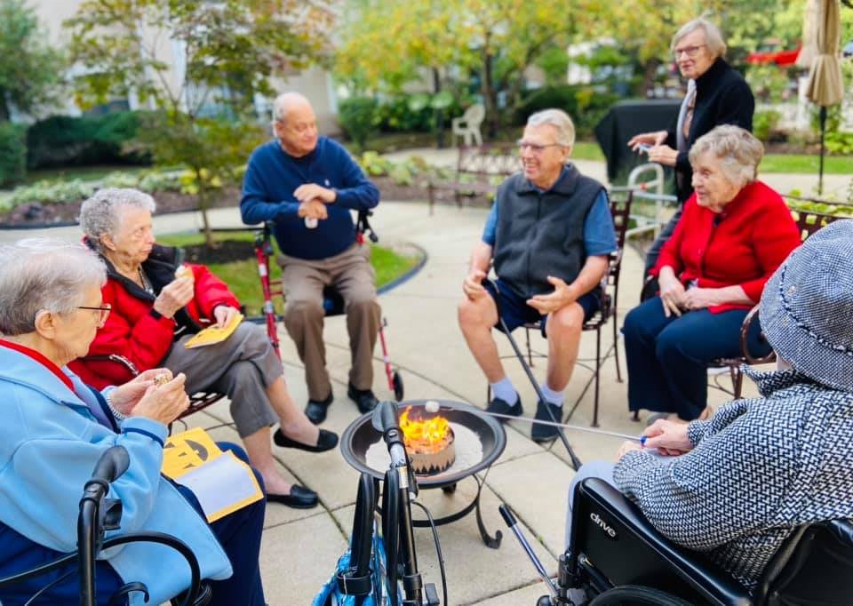 A group of seniors enjoying a conversation outdoors in a casual setting.