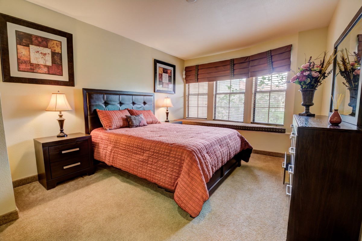 A cozy bedroom with a large bed and natural light from the window.